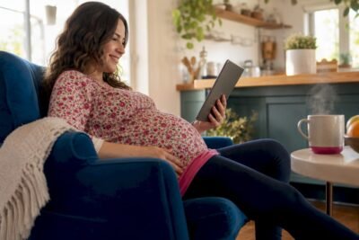 Pregnant woman using personalized pregnancy app at home
